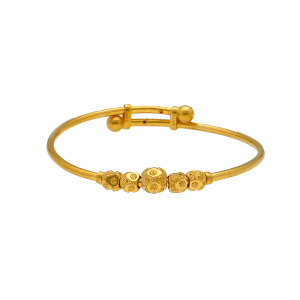 An image of a single 22K gold bangle with gold beads from Virani Jewelers. | Treat your little one to fine jewelry with this set of 22K gold bangles from Virani Jewelers!

Ma...