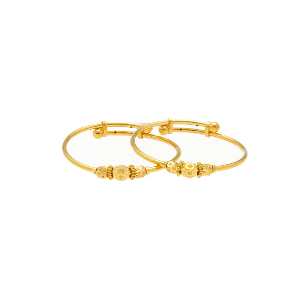 An image of two 22K gold bangles from Virani Jewelers overlapping each other. | Introduce your child to a world of elegance with this 22K gold baby bangle from Virani Jewelers!
...