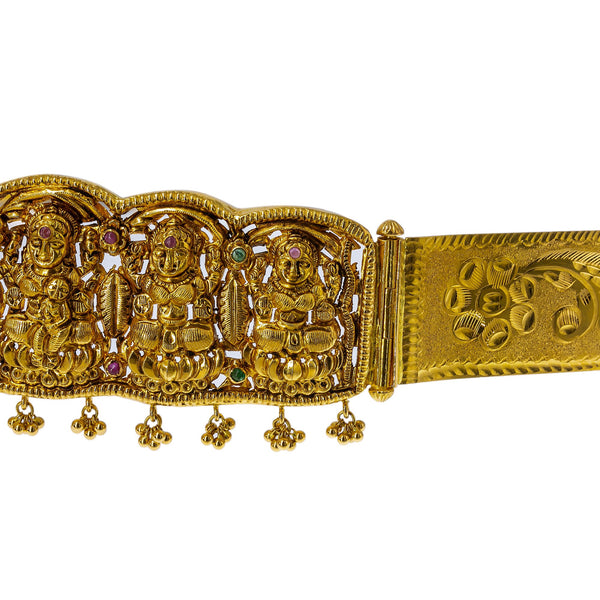 A side view of the 22K gold waist belt with detailed images of Laxmi adorned with precious rubies, emeralds, and hanging gold balls.  | Add movement and luxury to your most festive looks with Vaddanam waist belts that will transform ...